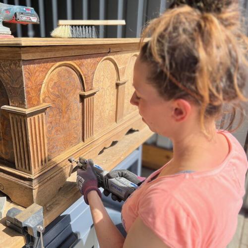 Vorsichtiges Abschleifen der antiken Truhe während des Upcycling Projektes